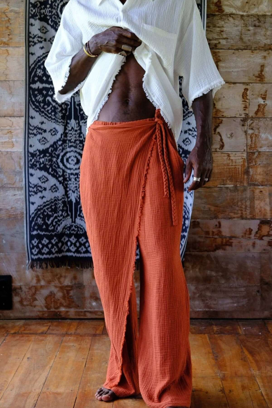 Model showcasing Nahara Pants Terracotta - Men with relaxed fit and wrap detail, styled for a breezy summer look.