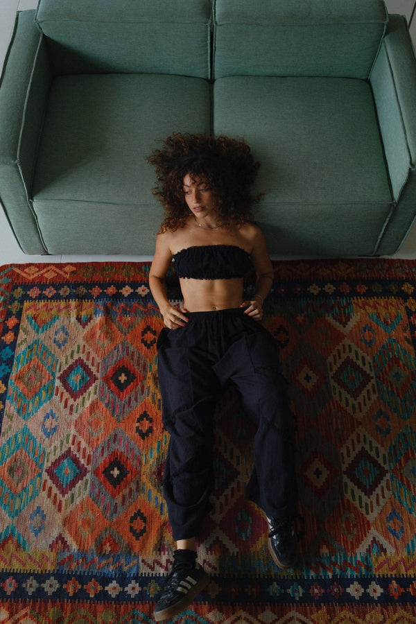 Resting on the teal couch and kilim rugs, dry-season afternoon