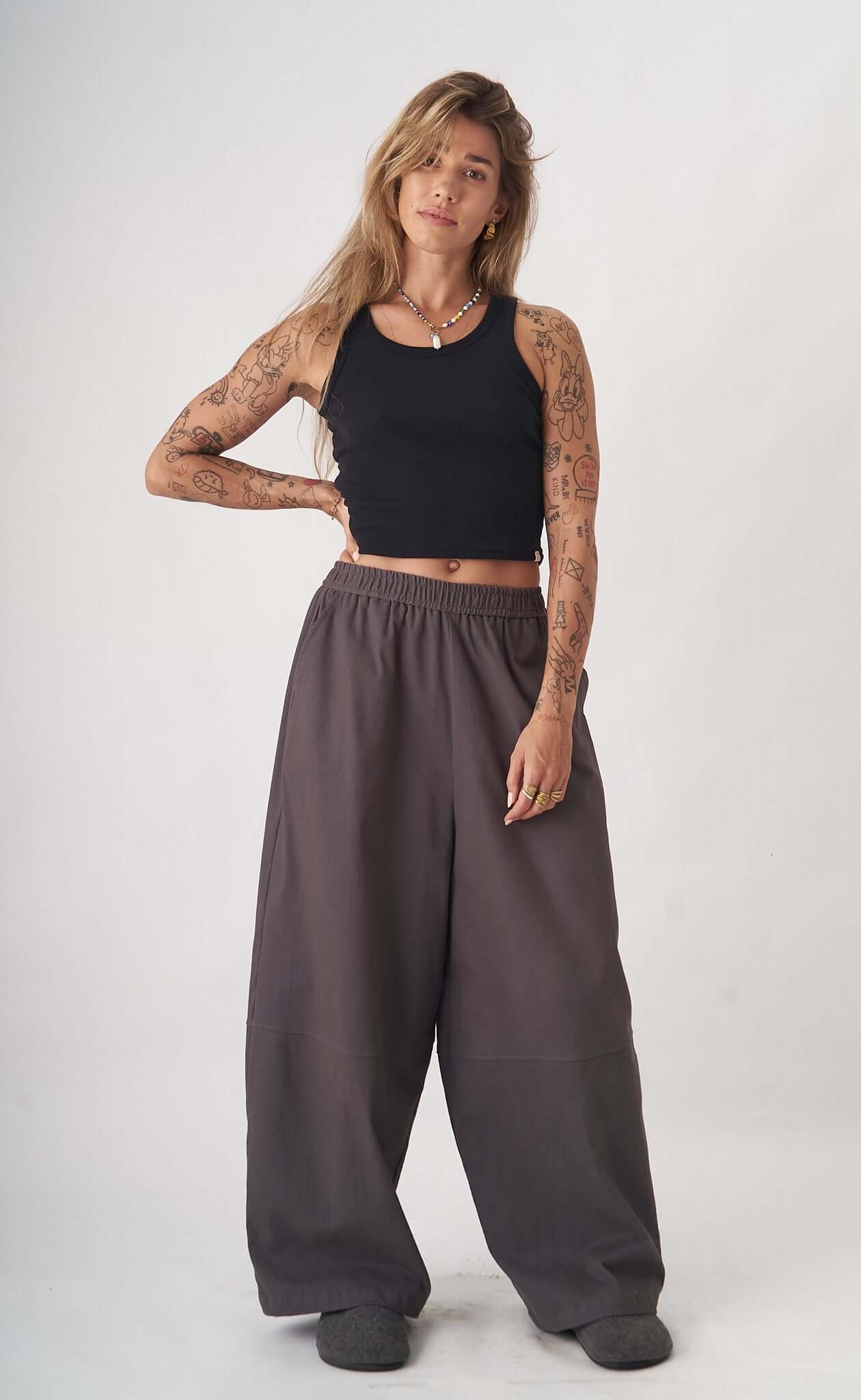 Coastline Trouser - Women showcased by a model wearing a black tank top and wide oversized gray trousers, embodying streetstyle and comfort.